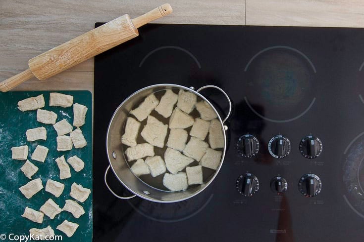 Homemade Cracker Barrel dumplings in a pot on the stovetop.