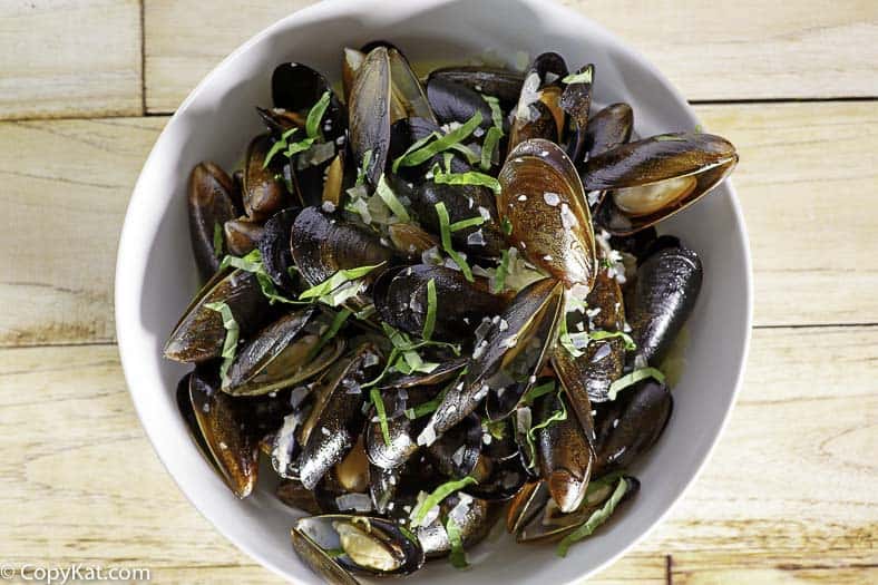 a bowl of mussels in white wine sauce