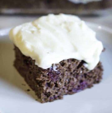 A slice of devil's food cake topped with cream cheese frosting