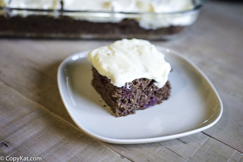 A piece of Devil's Food Cake with cherry pie filling, topped with cream cheese frosting