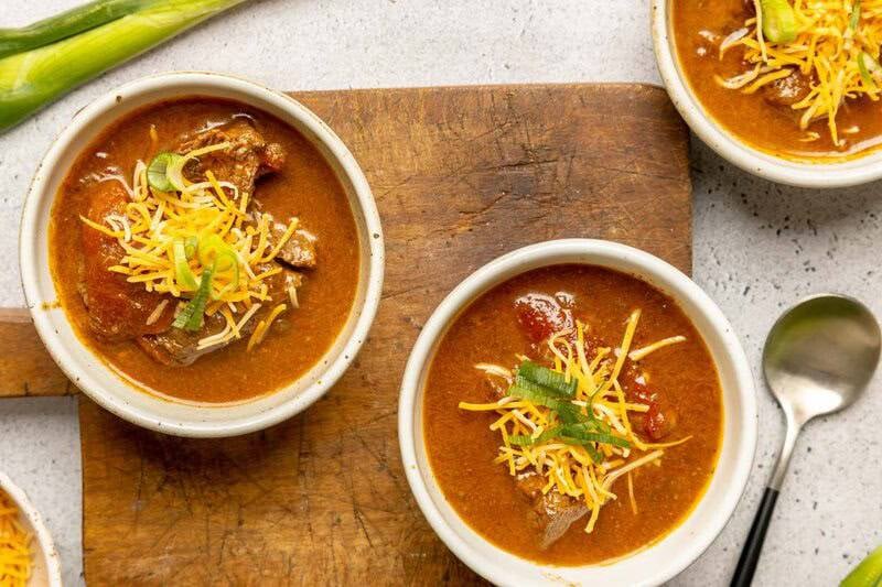 Lady Bird Johnson's Pedernales River chili garnished with cheese and green onions in three bowls.