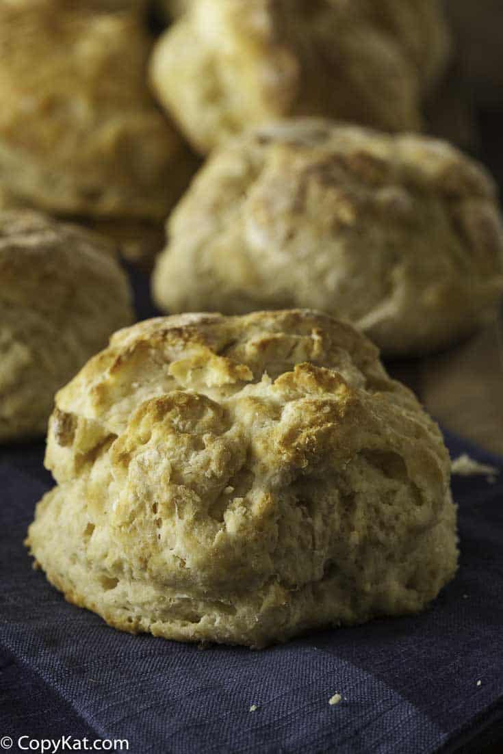 Fresh warm biscuits with browned tops on a towel. 