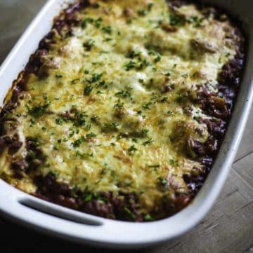 Four Cheese Manicotti with meat sauce topped with cheese in a baking dish