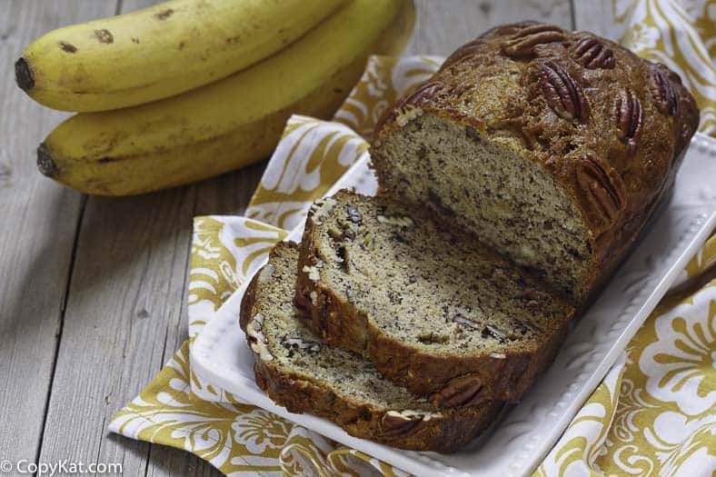 a loaf of banana bread cut into slices with pecans
