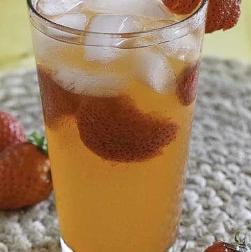 Homemade copycat Red Robin Freckled Lemonade and strawberries in a glass.