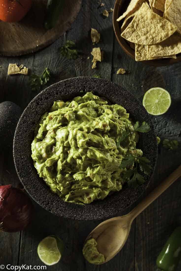 A bowl of guacamole made with fresh avocados and canned tomatoes. 