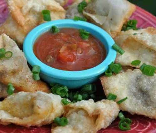 A plate of taco wontons and salsa