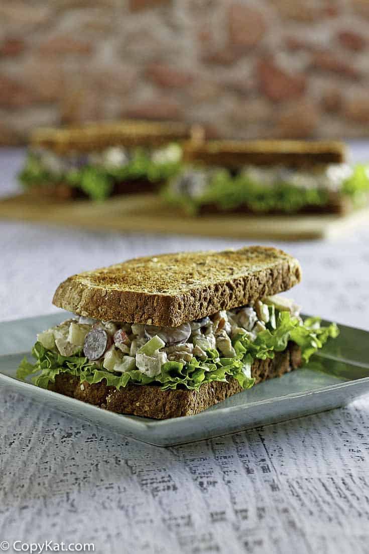 Homemade copycat Arby's Grilled Chicken Pecan Salad in a sandwich on a plate.