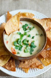 Applebees Queso Blanco dip in a bowl and tortilla chips on a platter.