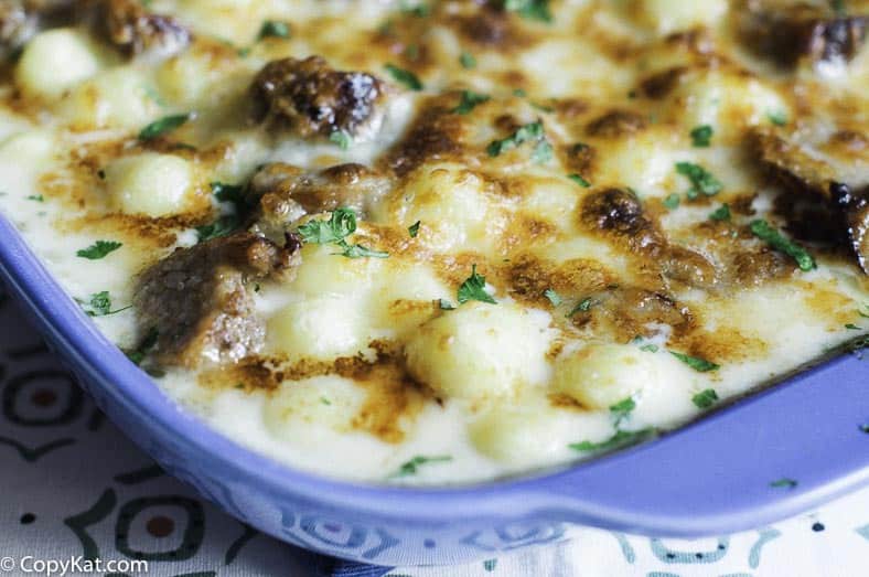 gnocchi, Italian sausage, and Alfredo sauce baked in a blue casserole dish