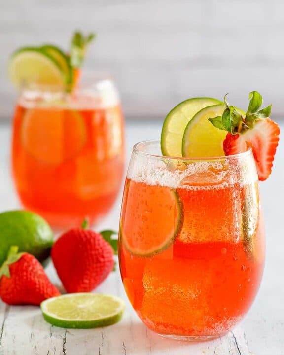Copycat Sonic strawberry limeade drinks, limes, and strawberries.