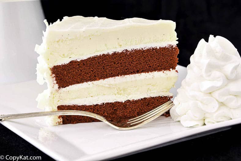 A slice of homemade Cheesecake Factory Red Velvet Cheesecake and a fork on a plate