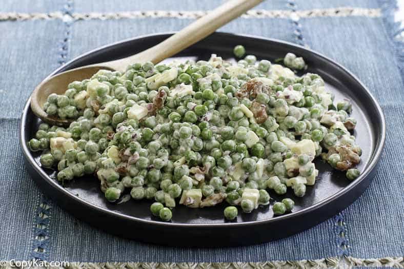 a plate of pea salad made with cheese and bacon