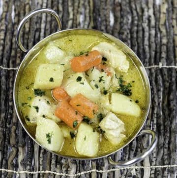 Thai yellow chicken curry with vegetables in a metal serving dish.