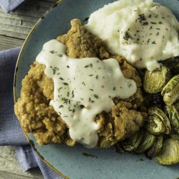 Homemade Southern Chicken Fried Steak and gravy with Brussels sprouts and mashed potatoes