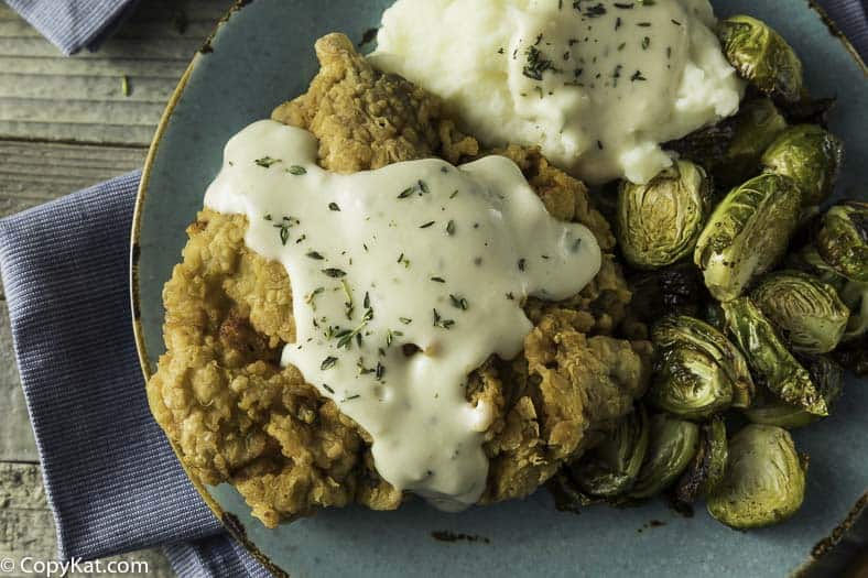 Chicken Fried Steak and gravy with mashed potatoes and Brussels sprouts