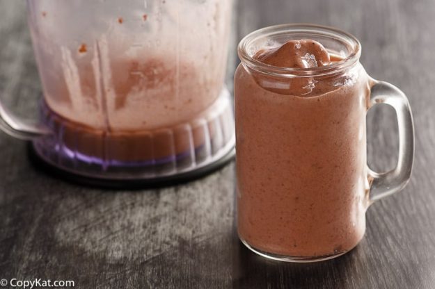 Homemade copycat McDonald's Strawberry Smoothie in a glass with a handle next to a blender.