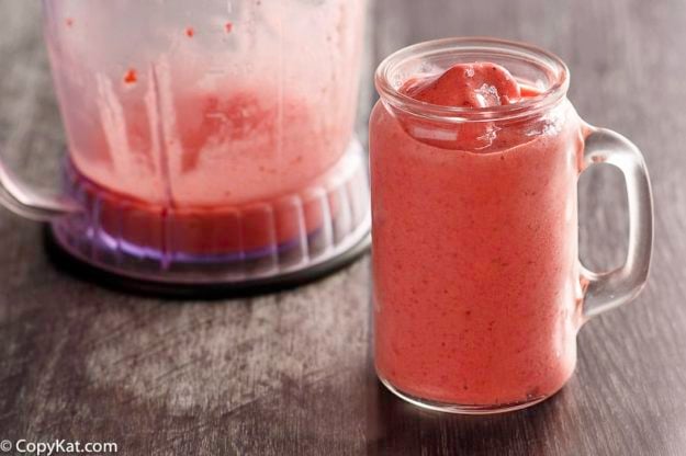 Homemade copycat McDonald's Strawberry Smoothie in a glass with a handle next to a blender.