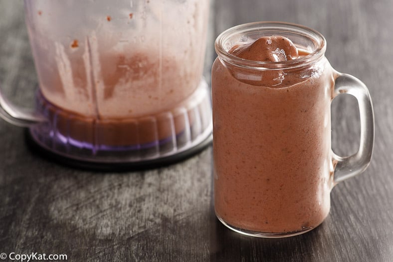 Homemade copycat McDonald's Strawberry Banana Smoothie in a glass next to a blender container.