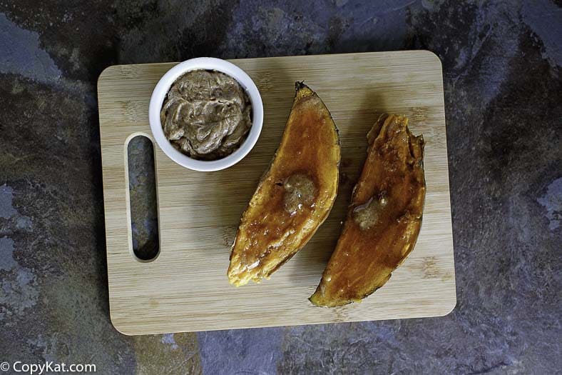 Homemade copycat Outback Steakhouse Baked Sweet Potato on a wood cutting board.