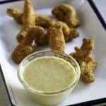 Homemade copycat Outback Steakhouse Honey Mustard on a tray with chicken tenders.