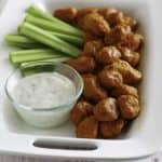 Boneless Buffalo Chicken Bites on a platter with blue cheese dressing and celery sticks