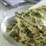 Homemade copycat Cheesecake Factory Chicken Piccata and pasta on a light blue plate.