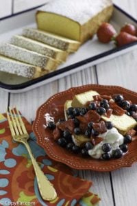 Homemade copycat Sara Lee Pound Cake with fruit in front of the cake on a platter.
