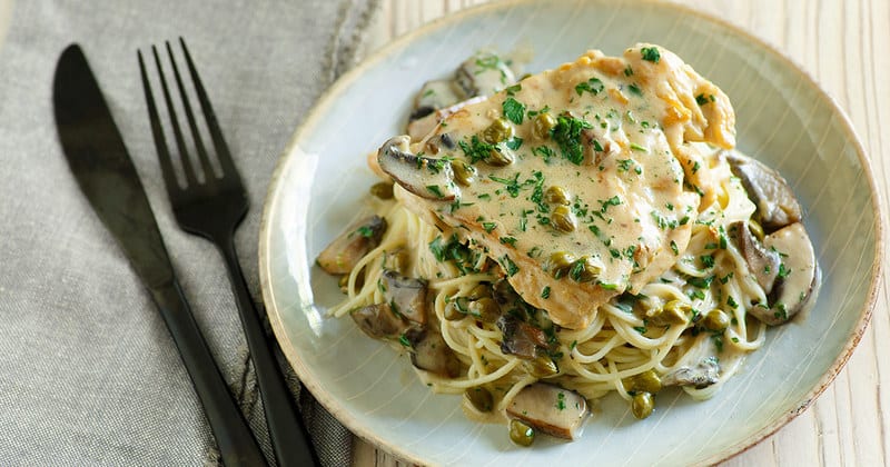 Homemade copycat Cheesecake Factory Chicken Piccata and pasta on a plate.