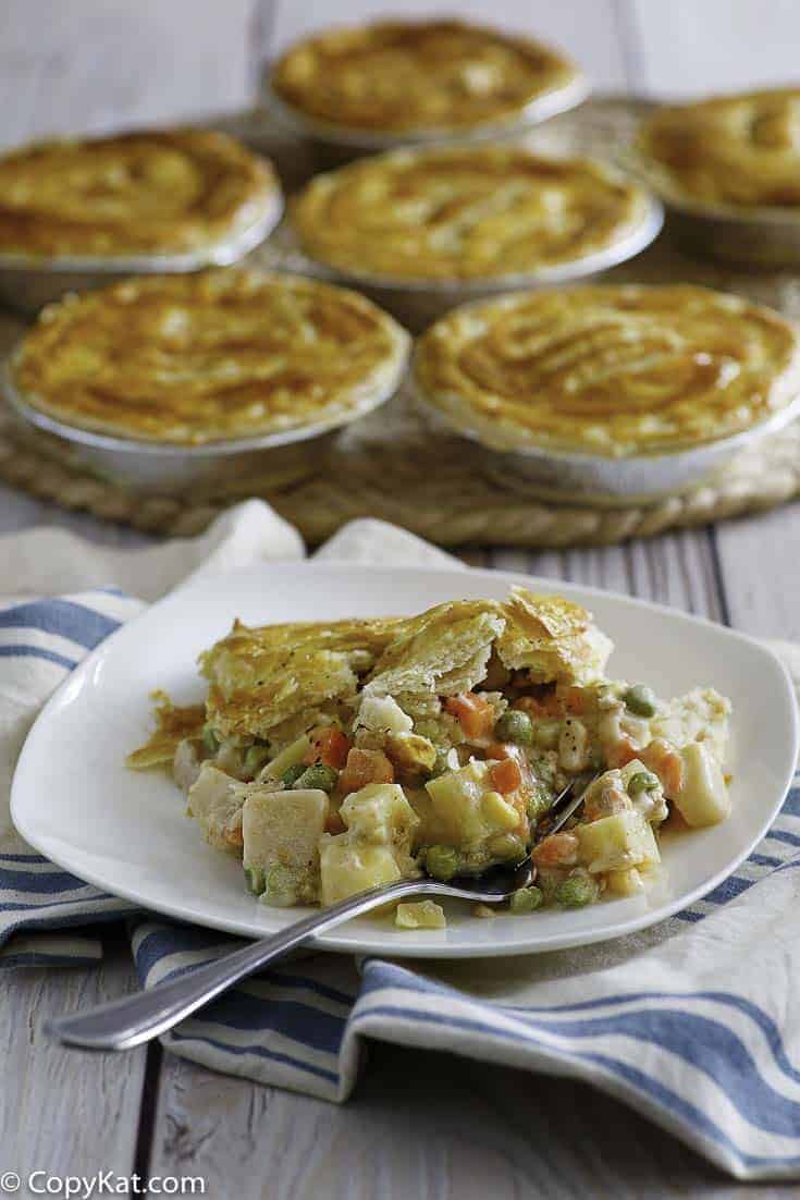 Homemade copycat KFC Chicken Pot Pie on a plate with more pot pies in the background.