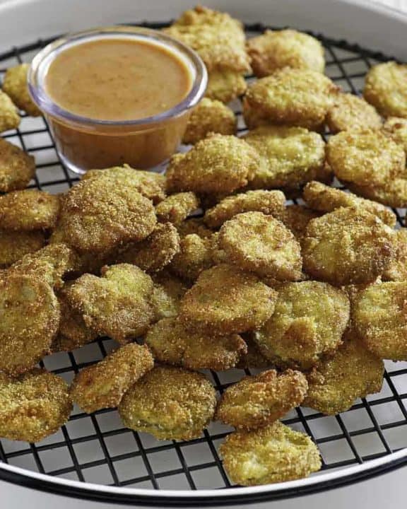 Homemade copycat Red Robin Pickle Nickels (fried pickles) and dipping sauce on a serving platter.