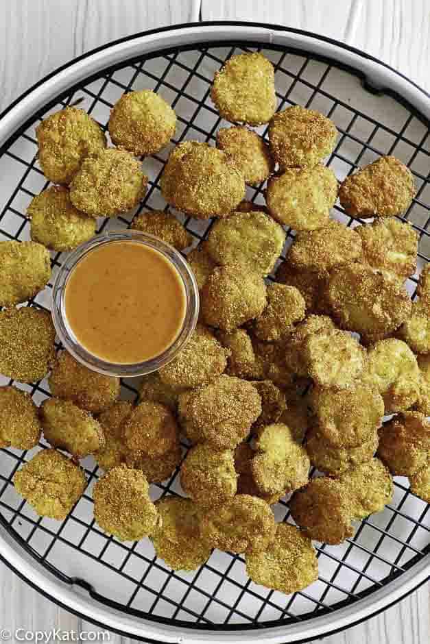 Homemade copycat Red Robin Pickle Nickels (fried pickles) with dipping sauce on a serving platter.