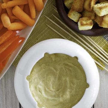 Homemade Melting Pot Traditional Swiss Fondue with vegetables and bread cubes.