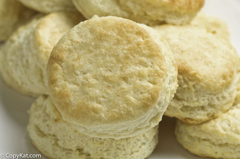 Tall fluffy biscuits arranged on a plate.