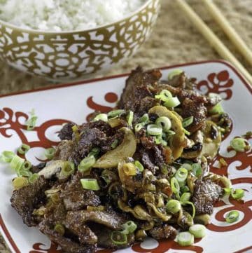 A plate of Mongolian beef and a bowl of rice.