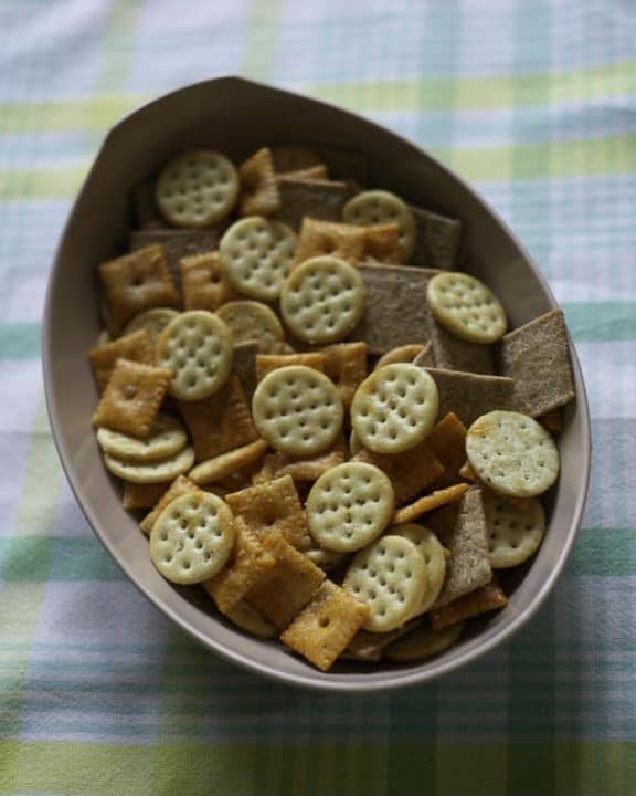 A bowl of three different types of seasoned crackers.