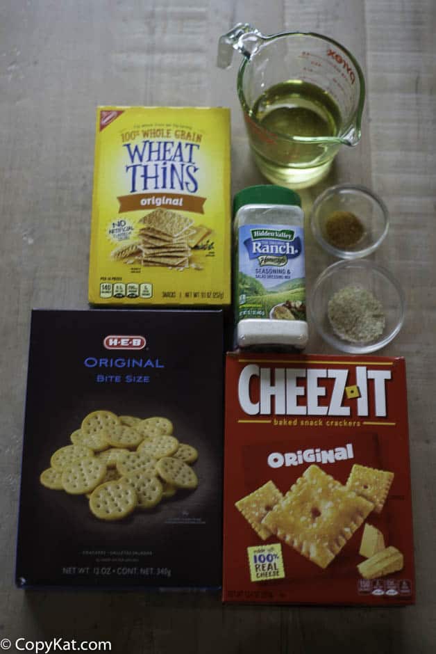 Three boxes of crackers, vegetable oil, seasoned salt, and garlic salt on a table. 