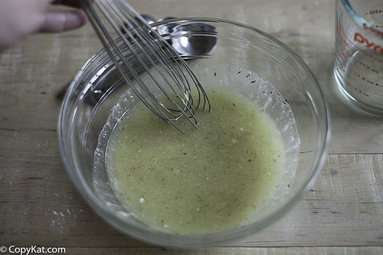 Mixing together vegetable oil, seasoned salt, dry Ranch Salad dressing mix, and seasoned salt. 