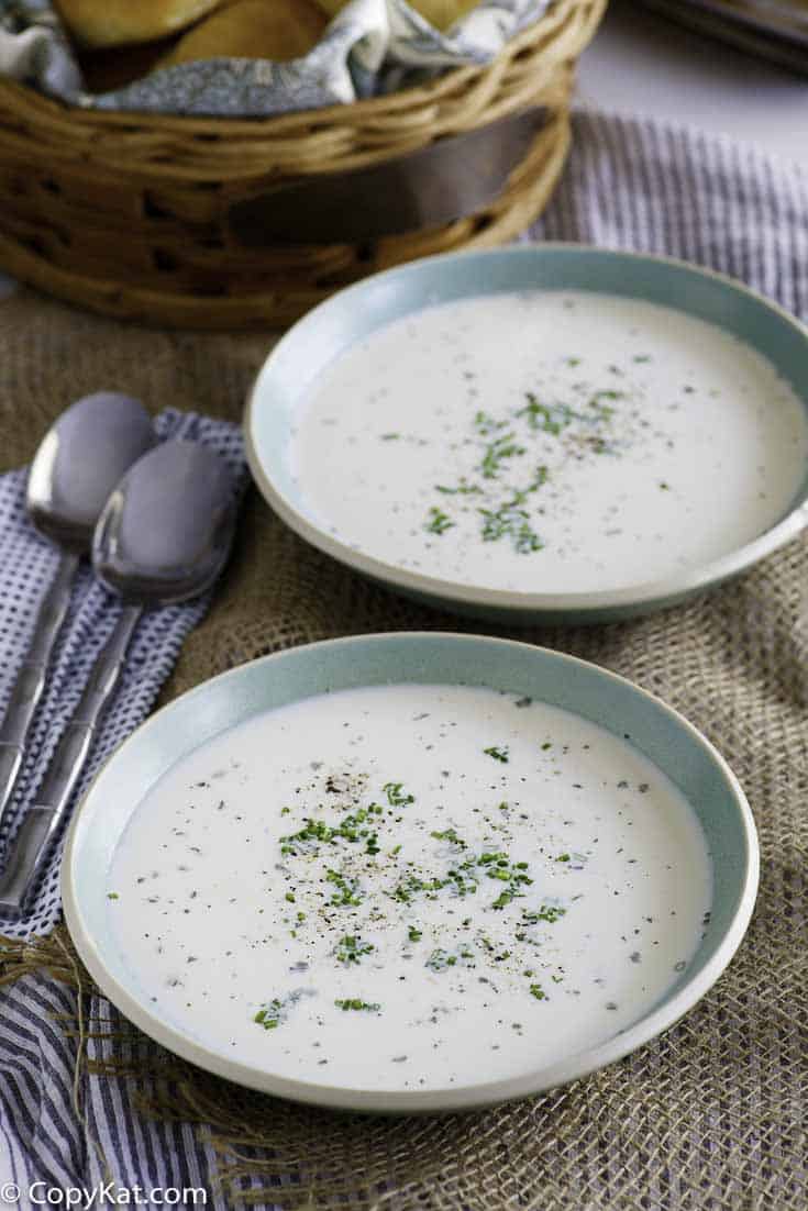 Two bowls of homemade potato soup with dried herbs sprinkled on top.