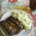 A plate of ribs and homemade coleslaw made with heavy cream, vinegar, and sugar