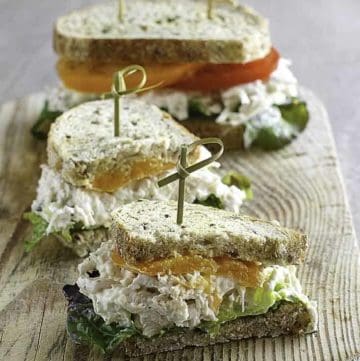 two chicken salad sandwiches on wheat bread with tomatoes and lettuce