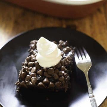 chocolate pudding cake with chocolate chips and whipped cream on top
