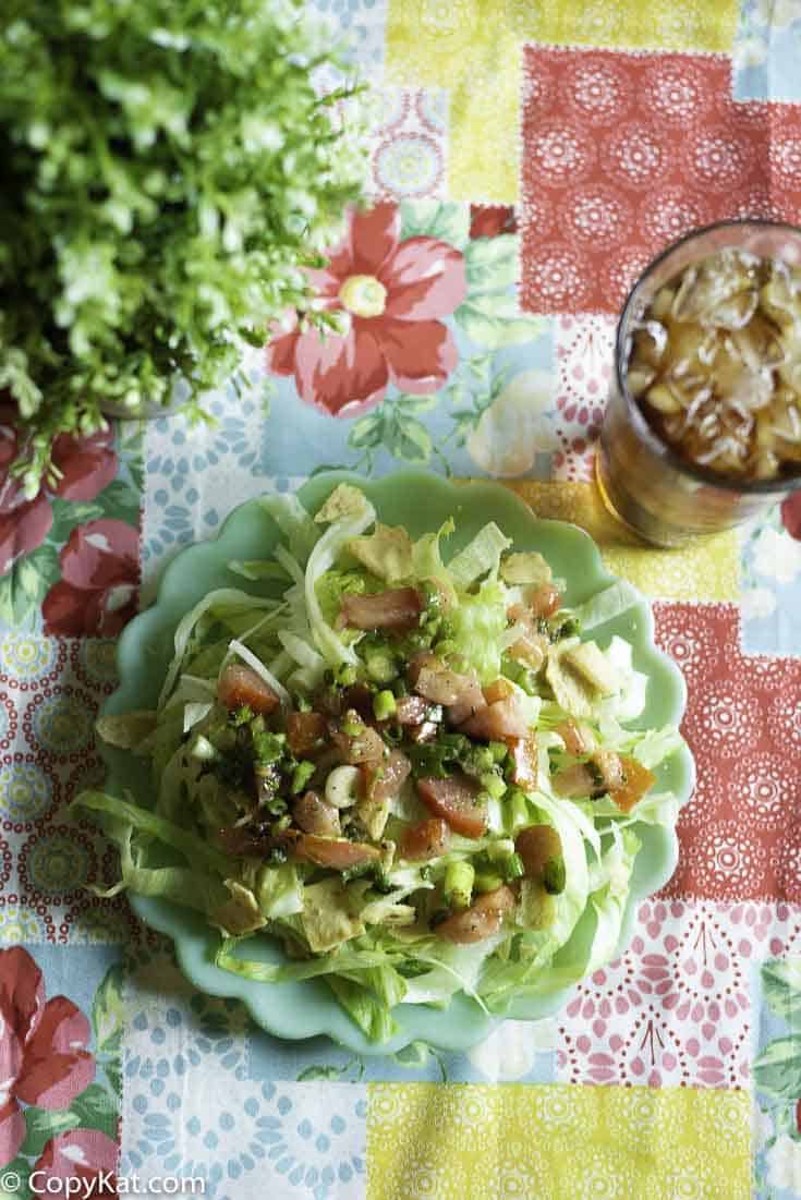 A plate of salad with tomatoes, iceburg lettuce with pita chips