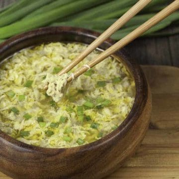 A bowl of egg drop soup with green onions.