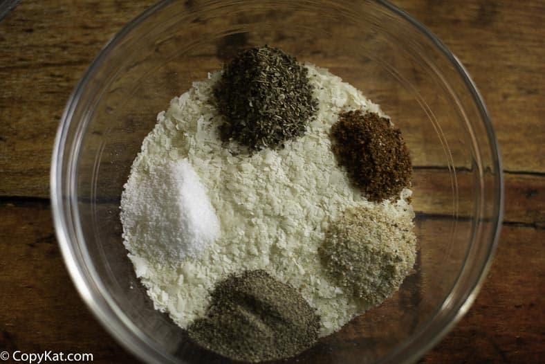 Instant potato flakes with seasoning like garlic salt, steak seasoning, and more in a bowl. 