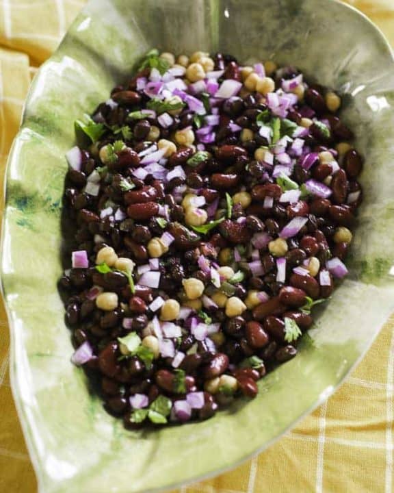 mexican three bean salad with red onions, cilantro in a bowl