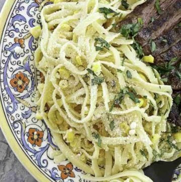 fettuccine pasta salad and steak on a plate