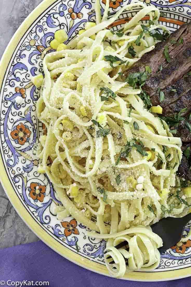 fettuccine pasta salad and steak on a plate