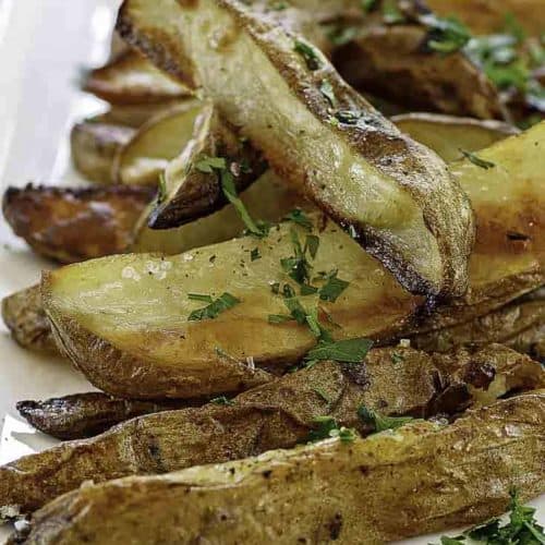 a plate of roasted potatoes with herbs