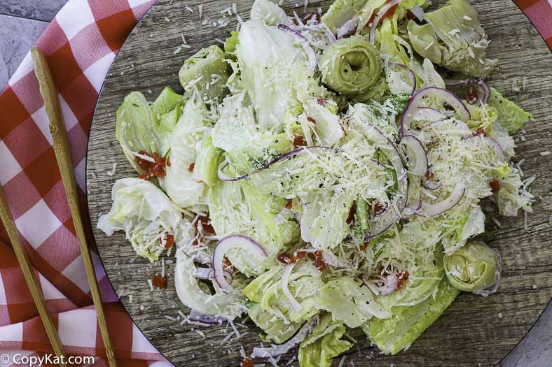 a plate with a salad of artichokes, lettuce, and more
